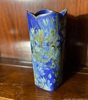 Front view of tall porcelain vase with blue and multicolor floral glaze pattern.