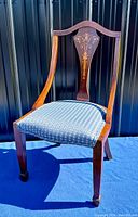 Front left angle view showing overall chair design, wood finish, and upholstered seat.