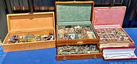 Three open jewelry boxes on blue cloth, showing the full assortment