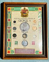Full view of framed set displaying Canadian King George V coinage and stamps with decorative border and crest