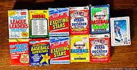 Multiple vintage unopened baseball card packs from 1987 to early 1990's including Fleer, Topps, and Kmart editions.