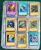 Three pages of Yu-Gi-Oh! trading cards in plastic binder sleeves, showing variety of monster, spell, and trap cards from vintage sets.