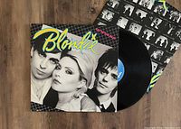 Photograph of Blondie Eat To The Beat LP vinyl record with sleeve and inner sleeve partly pulled out. Album cover shows three members of the band in black and white with 'Blondie' logo in bright colors.