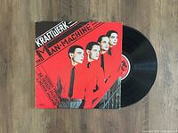 Front cover and vinyl record laid out showing artwork with four band members in red shirts on red and black background.