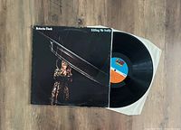 Photo of Roberta Flack 'Killing Me Softly' vinyl LP record alongside its original UK pressing cover sleeve showing front artwork and part of vinyl with label.