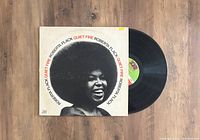 Top-down photo of Roberta Flack Quiet Fire LP vinyl record cover and partially visible vinyl record on a wooden surface.