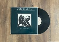 Front view of the Van Halen Women and Children First album cover and vinyl disc placed beside it.