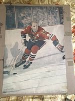Front of vintage 1970 Sports Illustrated poster depicting hockey player Bobby Hull in Chicago Black Hawks uniform skating on ice with puck.