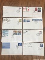 Eight Canadian First Day of Issue stamp covers arranged flat, showing stamps and cancellation marks.