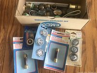 Top view of assorted cartridge fuses in blister packs and loose fuses in box