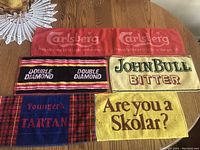 Top view of all five bar mats on a wooden table, showing branding and size differences.