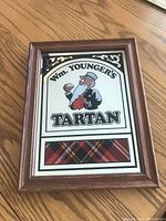 Framed mirror showing Wm. Younger's Tartan Scottish Beer design including tartan pattern and illustrated character.