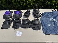 Lot contents displayed on table including knee pads, wrist guards, and travel/storage bag.