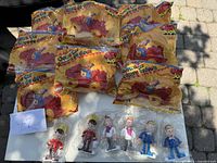 Photo showing 10 unopened Lego Duplo figurines in original sealed packaging with yellow backing featuring illustrations of toys and clowns.