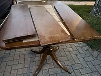 Photo of three wooden inserts laid on top of the dining table surface showing table extension pieces.