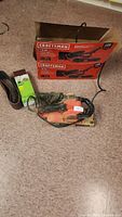 Craftsman belt sander, original box, and sand paper belts on floor