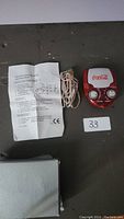 Portable Coca-Cola branded radio with two knobs, original instructions, and power cord, shown next to its white box.