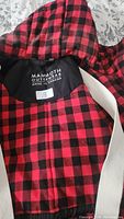 Close-up of Mammoth Outerwear label showing brand, size small, and Canadian manufacture