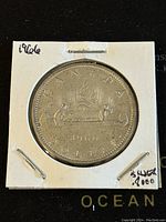 Reverse side of the 1966 Canadian silver dollar coin showing the canoe scene and inscriptions.