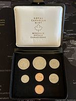 Set of 7 Canadian specimen coins from 1975 arranged in original Royal Canadian Mint case with black velvet and white satin lining.