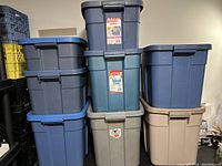Photo showing six Rubbermaid storage containers stacked in pairs of varying colors and sizes.