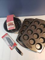 Lot contents showing Nordic Ware Rose Bundt Pan, two muffin pans, and Martha Stewart Cake Knife.