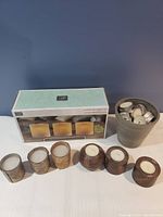 Lot showing boxed SP Home three-piece candle set, six small rustic candle holders with candles, and gray container with tealight candles.
