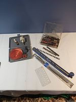Full view of the drill bits, hole saws, and accessories laid out on white surface.