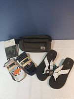 Fashion lot items including socks, flip flops, and Carhartt waist bag displayed on white surface