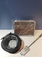 Camp table wrapped in clear plastic, showing wood grain surface and foldable design.