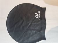 Photo of a single black oversized shower or swim cap with DSINE logo on white background.