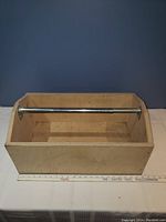 Front view showing full wooden toolbox with metal handle and ruler for scale