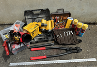 Lot includes 24-inch bolt cutters, a mobile tool kit with zipper, yellow DeWalt DC5001H filter box, assorted cans of Great Stuff spray foam, flashlights, jigsaw blades, digital tire gauge, doorstop, holesaw, and various hand tools around a 40-inch metal ruler.