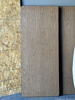 Top view of one banquet table showing wood grain laminate surface with minor wear.