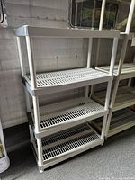 Two beige 4-tier Keter plastic shelving units standing upright showing full height and shelf design.