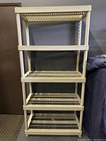 Beige 5-tier plastic shelving unit facing front showing all shelves and structural frame