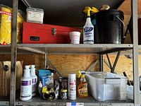 Shelf with red metal toolbox, various cleaning supplies including Hepastat RTU bottles, Zep spray, black bucket, and other small containers