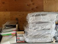 Stacked mattress bags, several packs of terry towels, and visible smoke alarm packaging.