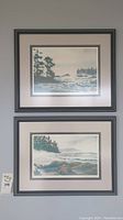 Two framed coastal landscape prints hung on wall
