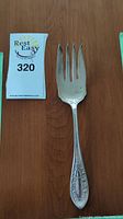Silver serving fork shown from top view displaying handle detail and fork tines indicating design and condition.