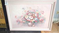 Framed floral painting in pastel colors with a bouquet in a vase, light pink frame.