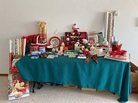 Full view of table with all Christmas decorations and wrapping paper rolls