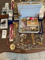 Top view showing the entire assortment of costume jewelry and boxes laid out on a wooden surface.