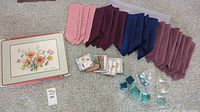 Overview photo showing cloth napkins, coasters, acrylic place mat, and floral centerpiece decor arranged on floor.