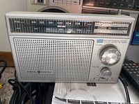 General Electric FM/AM radio front with tuning scale, power and volume controls, and speaker grille.