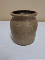 Front view of the antique stoneware crock showing its full shape and exterior condition.