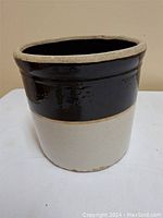 Front and side views of a vintage stoneware crock with dark brown and beige glaze