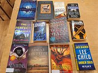 Full lot of 12 books displayed side by side on a wooden floor showing titles and cover art.