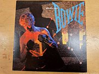 Front cover of David Bowie LP showing the artist with text and graphic design elements.