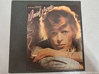 Front cover of David Bowie Young Americans LP album showing Bowie with cigarette and bracelet and artwork details.